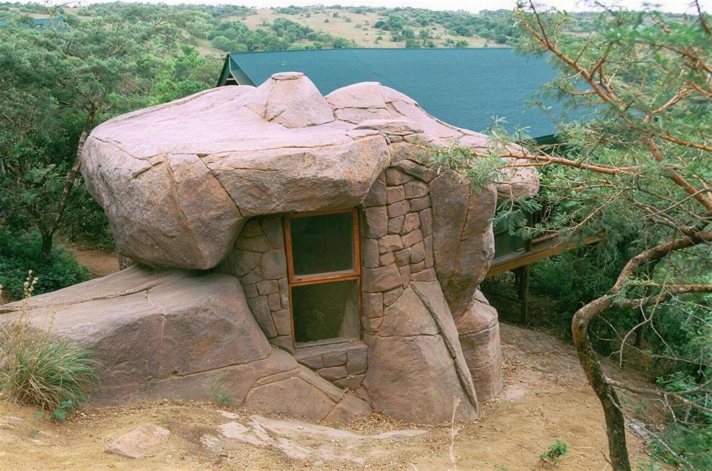 The cave-style shower room at Bush Camp built into a sandstone boulder with a window cut through the rock.