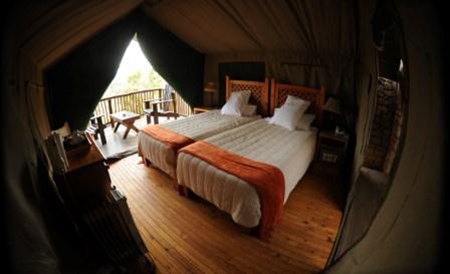 Inside a Bush Camp tent, twin beds with slatted headboards.