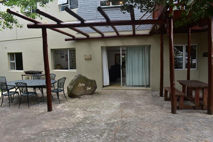 The pergola-shaded courtyard of Chintsa Sands guesthouse with outdoor dining tables.