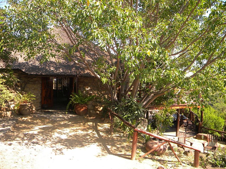 The interior of the Sunset Lapa, stone walls and thatched roof above timber tables.