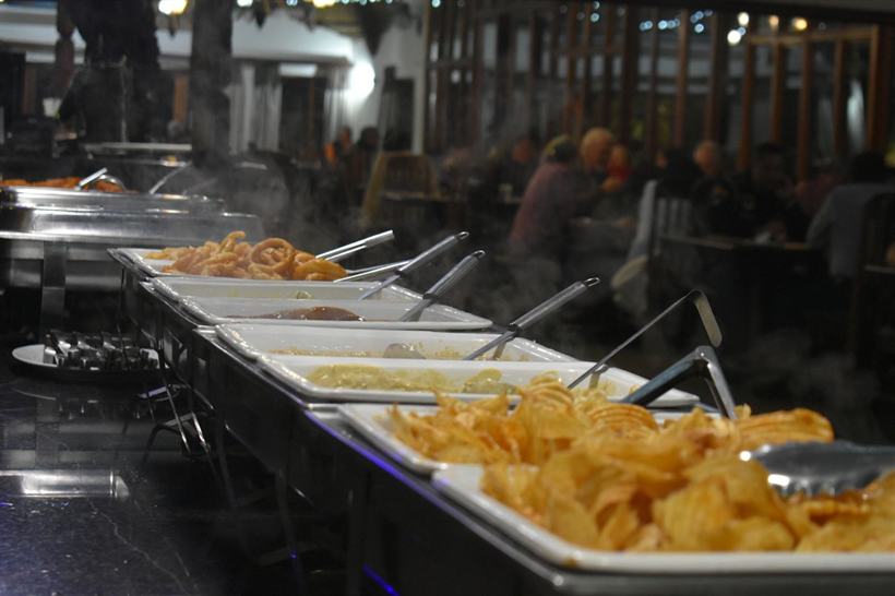 A buffet service laid out under warming lamps.