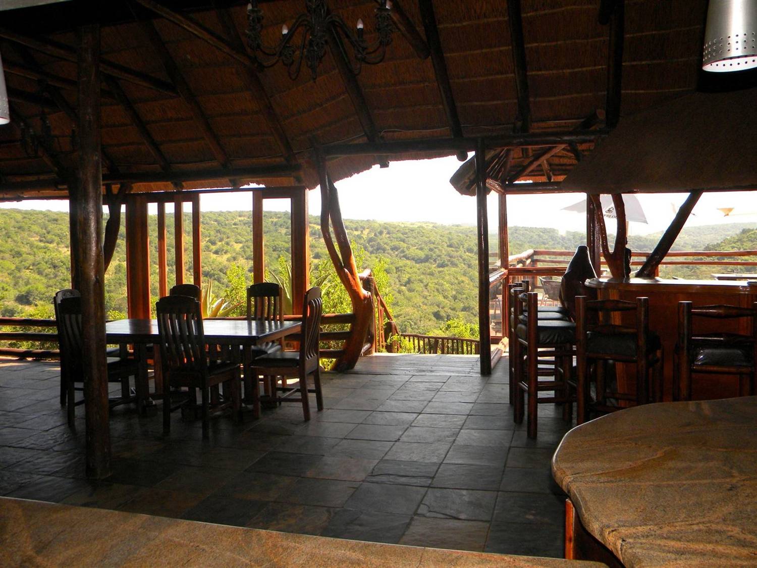 The Sunset Restaurant's thatched roof and stone floor open onto a view across wooded valleys.