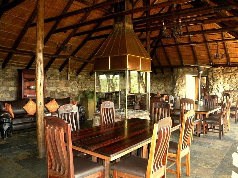 The restaurant terrace set for evening service with the bush beyond.