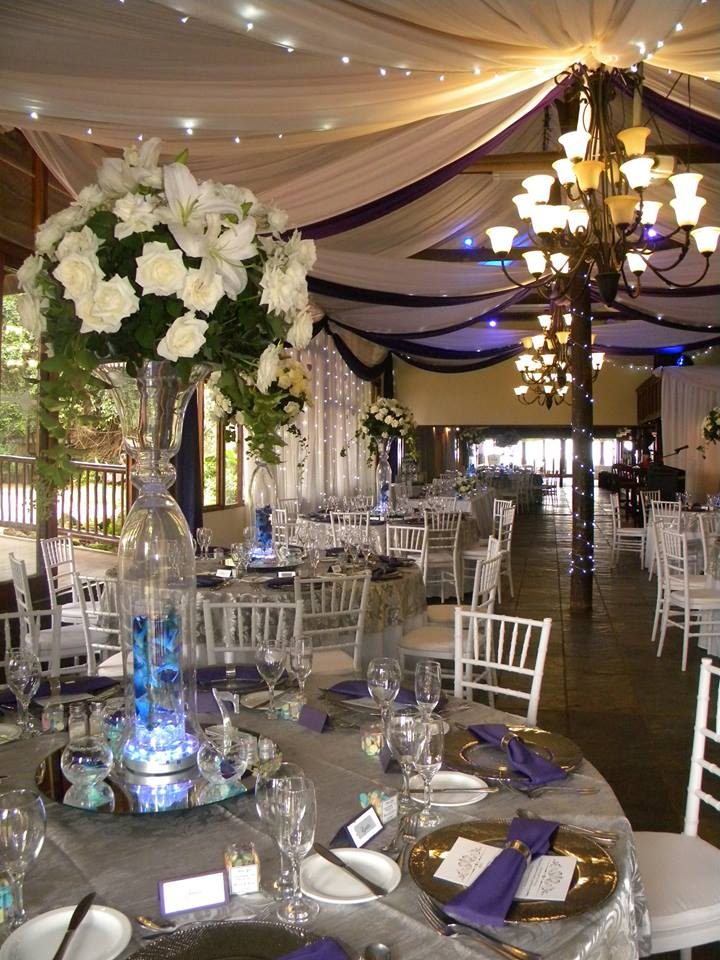 Floor-length tablecloths, candelabras and greenery in the reception venue.