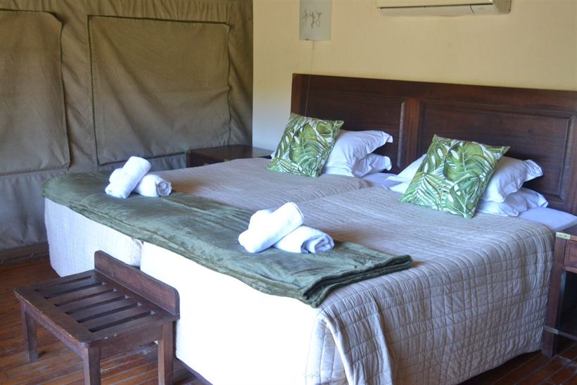 Twin beds made up with percale linen inside a canvas-walled tent at Valley Camp.